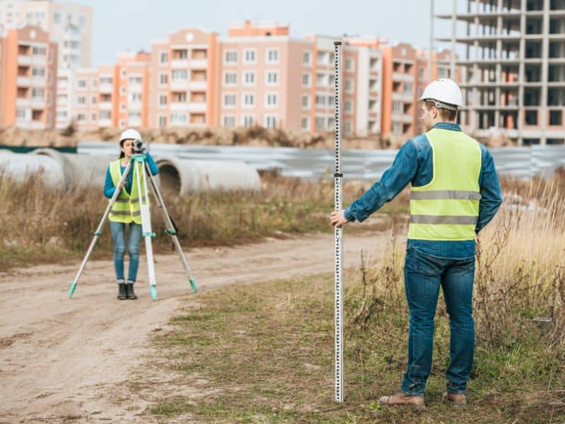 Land surveyor working on construction site layout using precision surveying equipment to ensure accurate measurements and prevent project delays